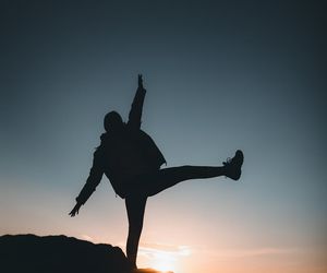 Silhouette of a person in a balance pose at dawn.